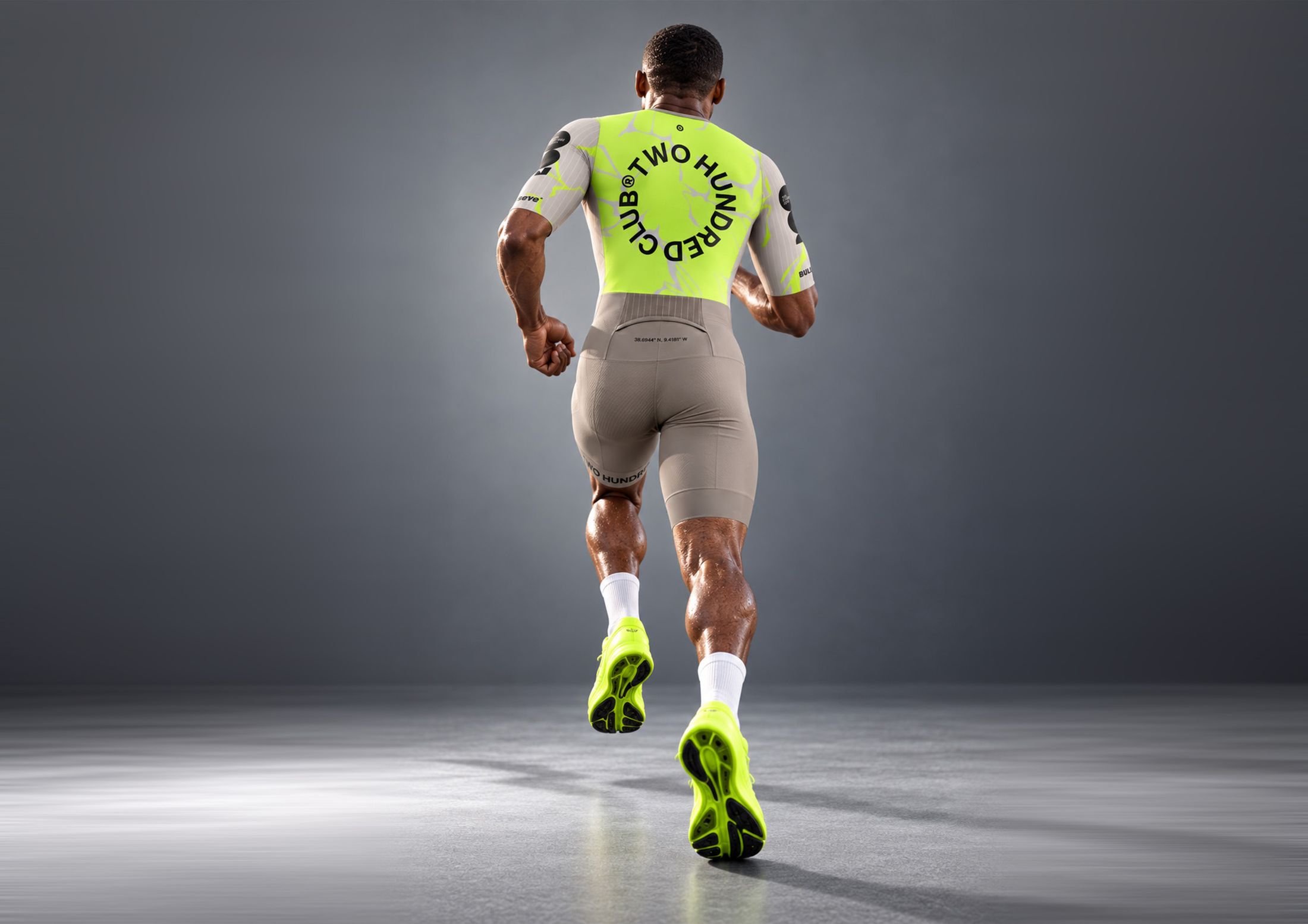 Atleta a correr de costas, com o painel lima e o lettering circular Two Hundred Club.